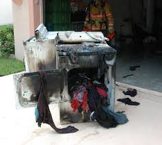 technician inspecting dryer drum after homeowner reports dryer smells like burnt rubber